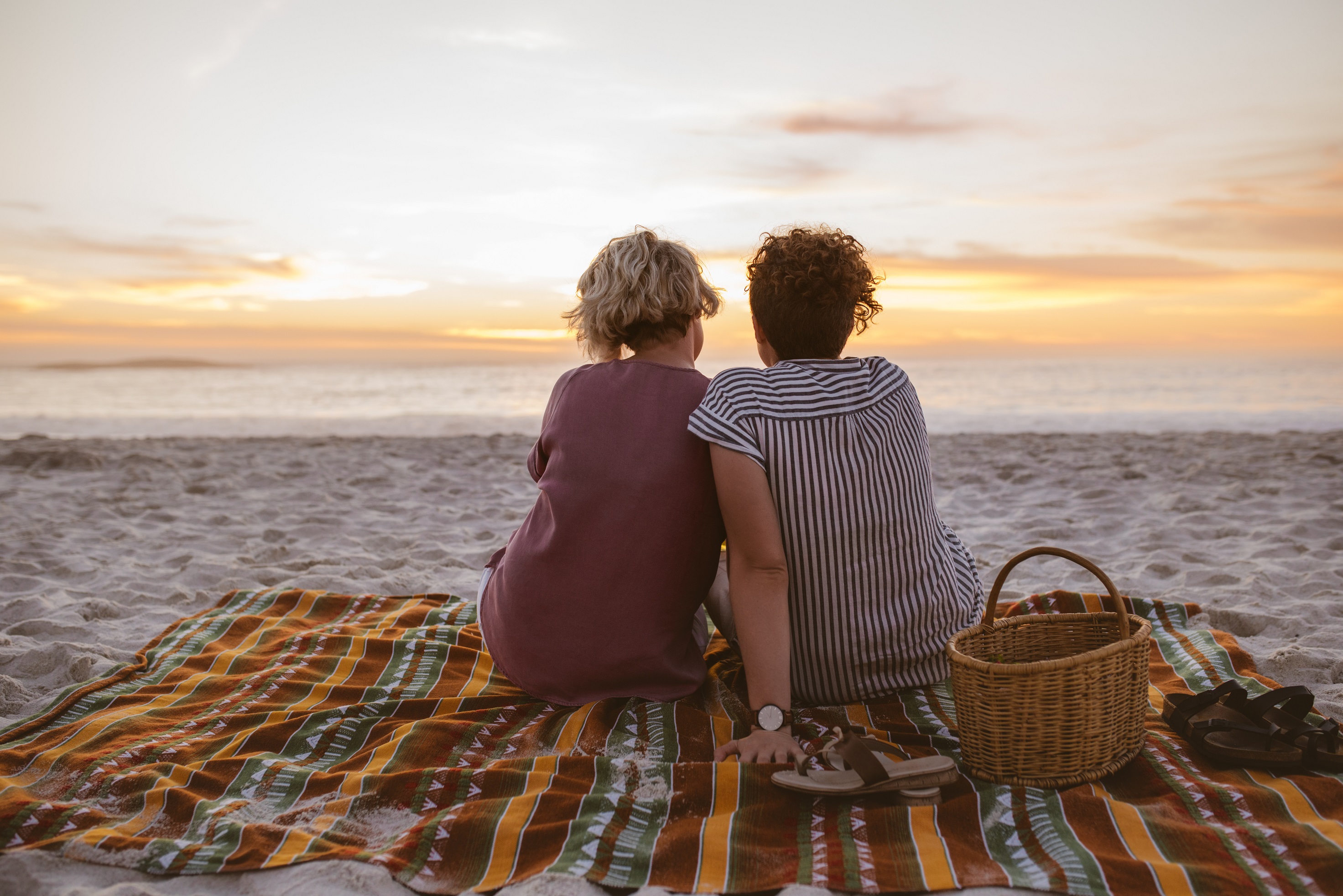 young-lesbian-couple-watching-a-romantic-sunset-at-the-beach_224539288.jpeg