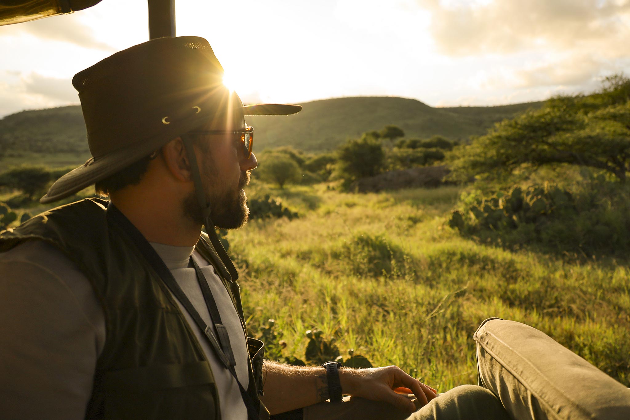 header-young-man-in-safari-jeep-on-game-drive-looking-out_392134929.jpg