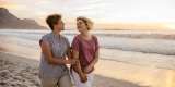 Smiling lesbian couple enjoying a romantic walk along a beach