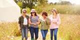 Group of mature female friends walking along path