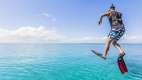 Man with snorkelling gear leaping into the water